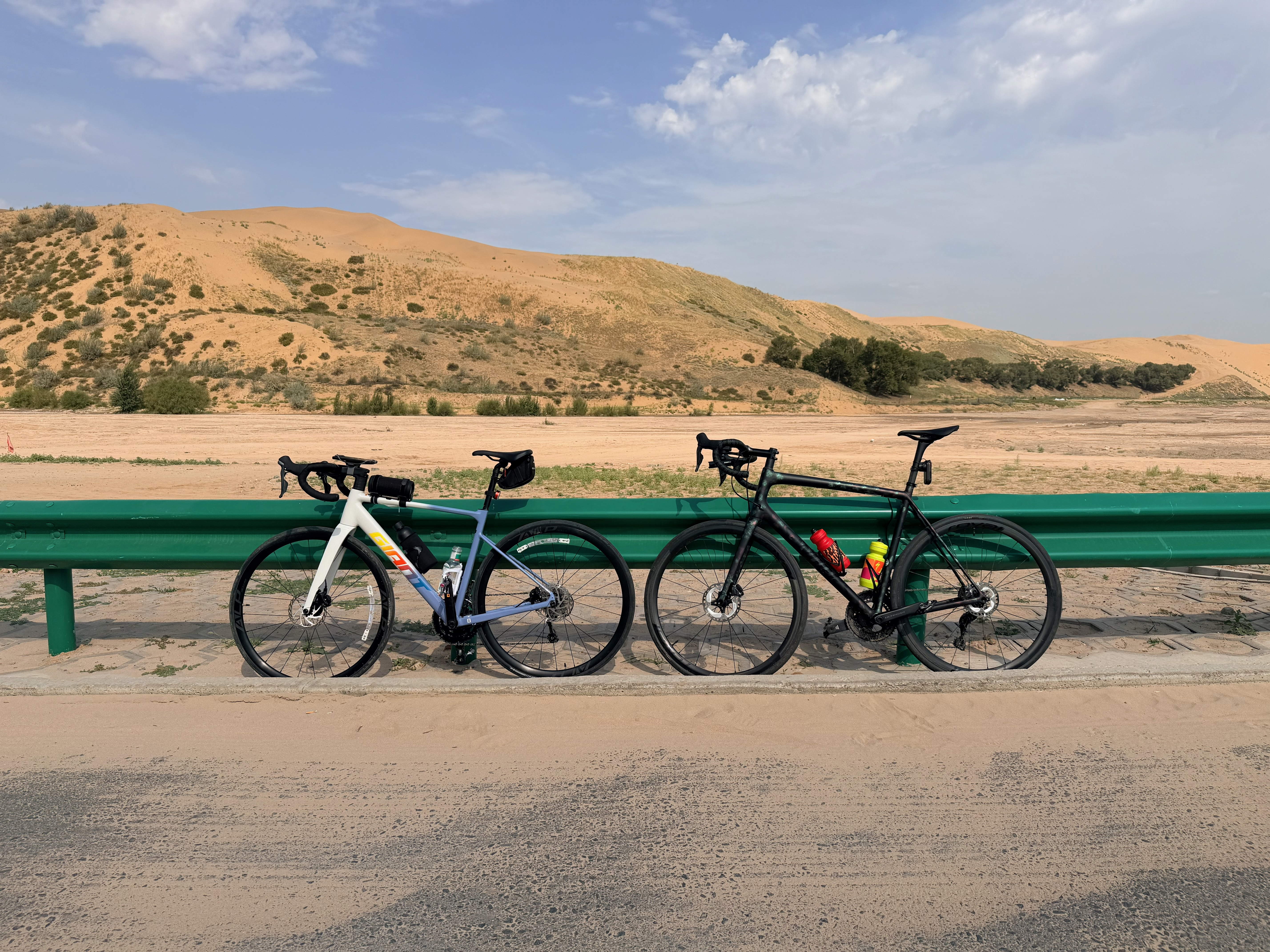 Two bikes in front of desert sand