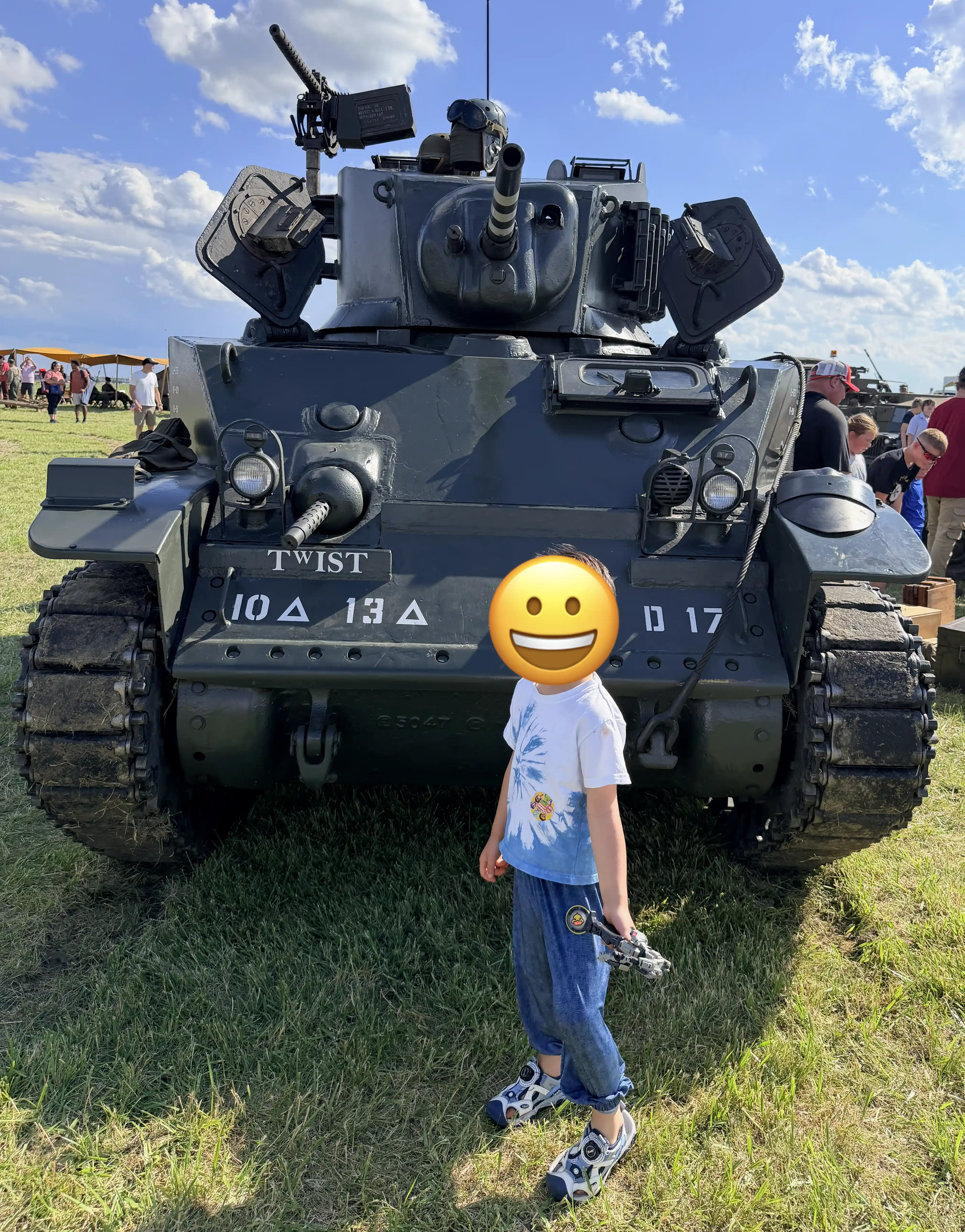 Kid standing infront of a tank